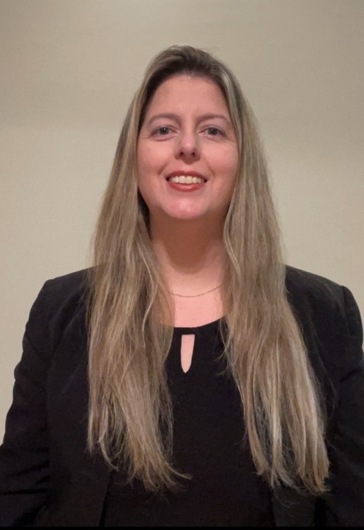 Retrato de primeiro plano de Mariana, uma mulher adulta de pele clara, sorrindo para a câmera